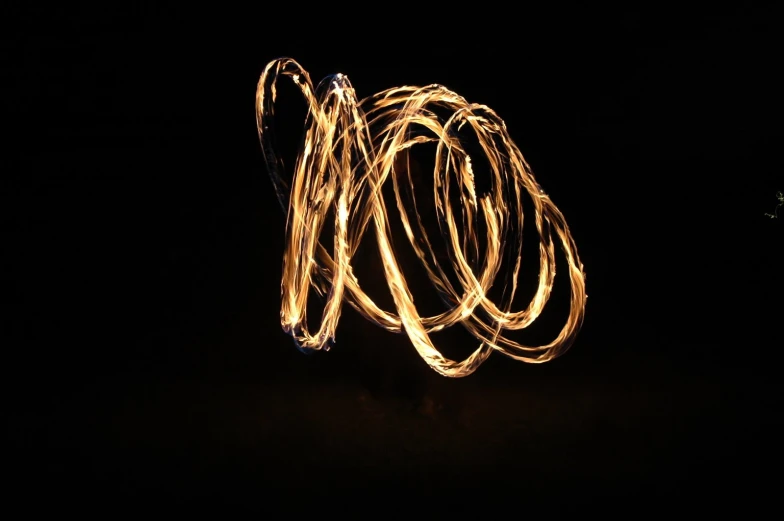 a fire dancer is in motion on the dark background