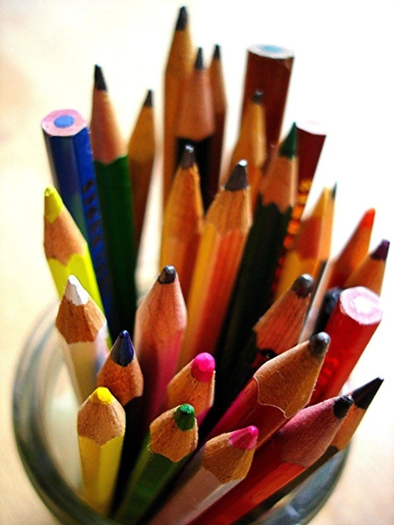 a cup filled with a group of colored pencils