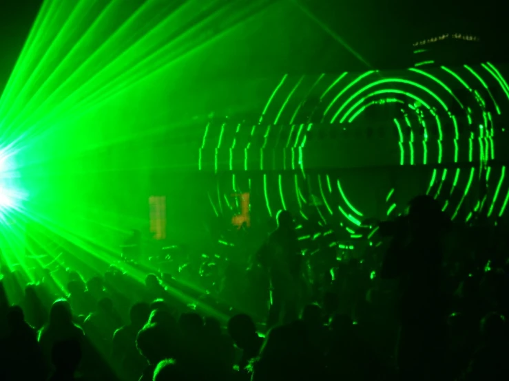 a group of people standing in front of green laser lights