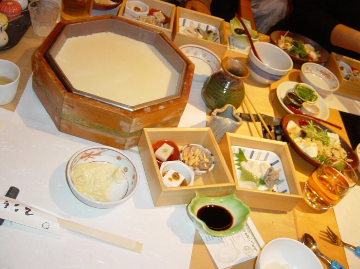 various bowls and dishes on a table with utensils