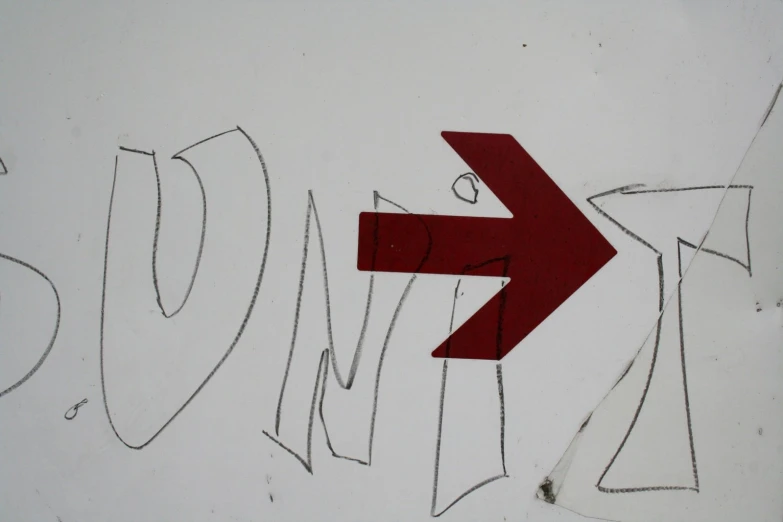 a close up of a graffiti written in red on a wall