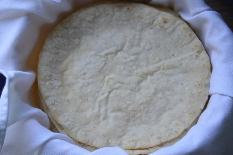 a tortilla on a white cloth and folded in napkins