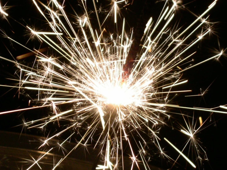 white sparkler exploding in the sky with the dark background