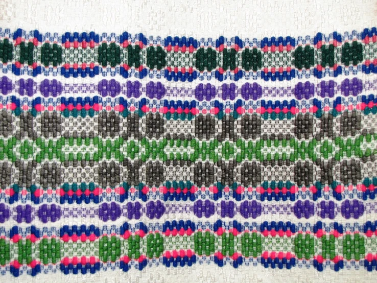 a piece of cross stitch, with multiple stripes and designs