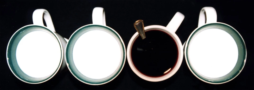 four tea cups sitting side by side next to each other