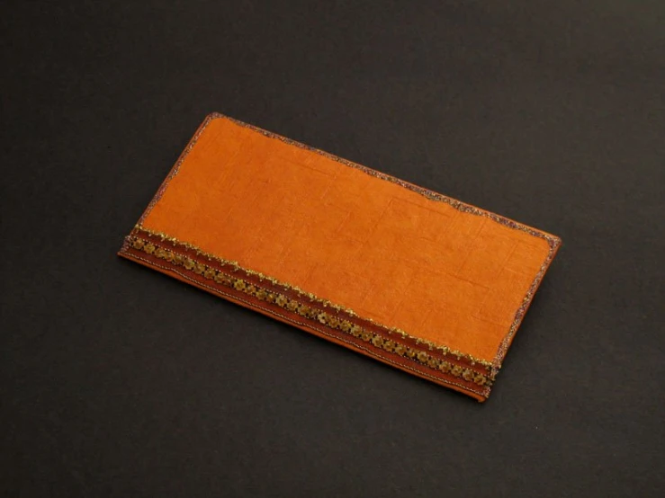 a brown leather card case sitting on a black table