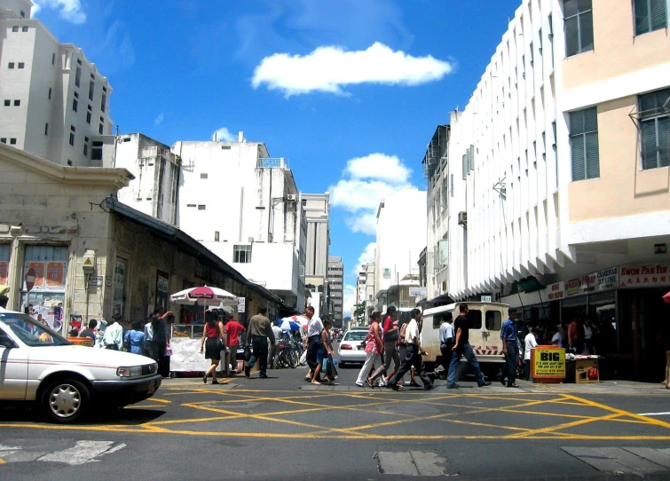 a bunch of people walking around a busy city street