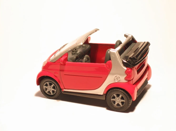 a small red and white toy car with luggage inside