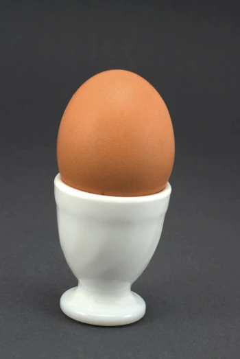 an egg sitting on top of a white cup