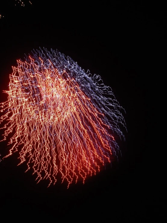 a large fireworks is exploding in the dark