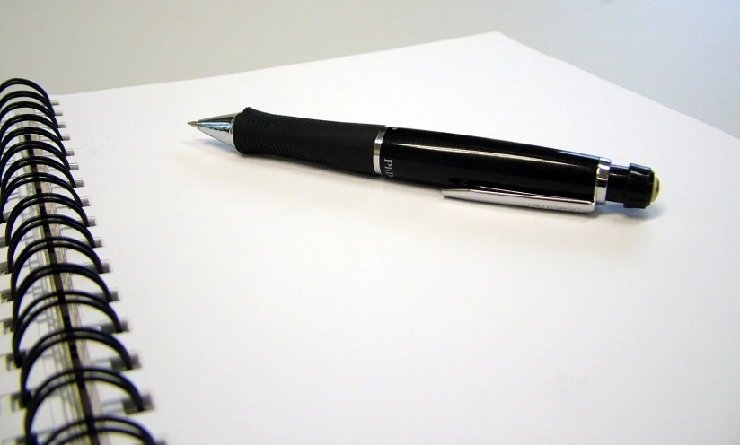 a notepad and pen resting on top of a white table