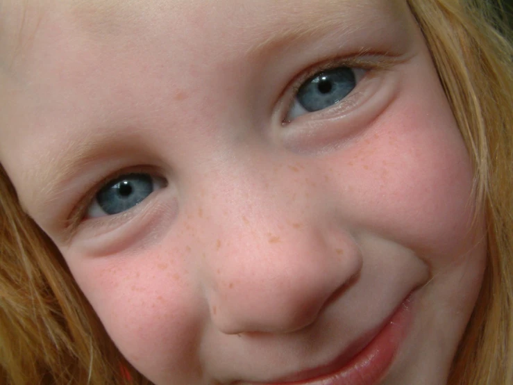 a close up of a 's face with blue eyes