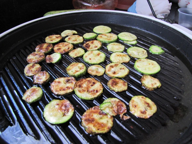 some cut up zucchini on a big grill