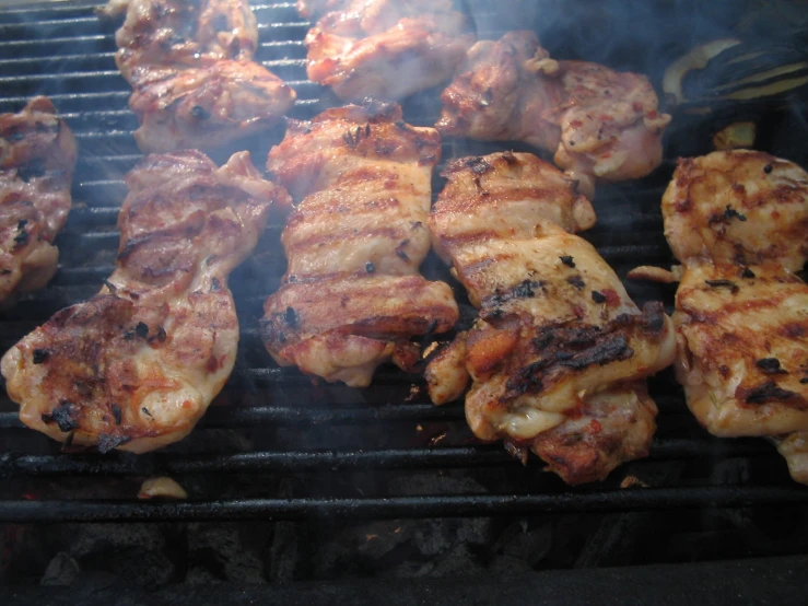 some pork on a grill being cooked with flame