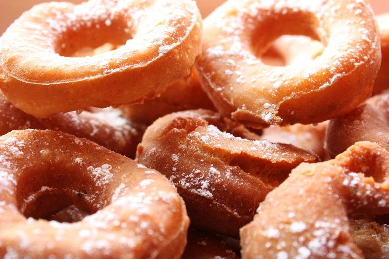 several glazed doughnuts in a pile on a plate