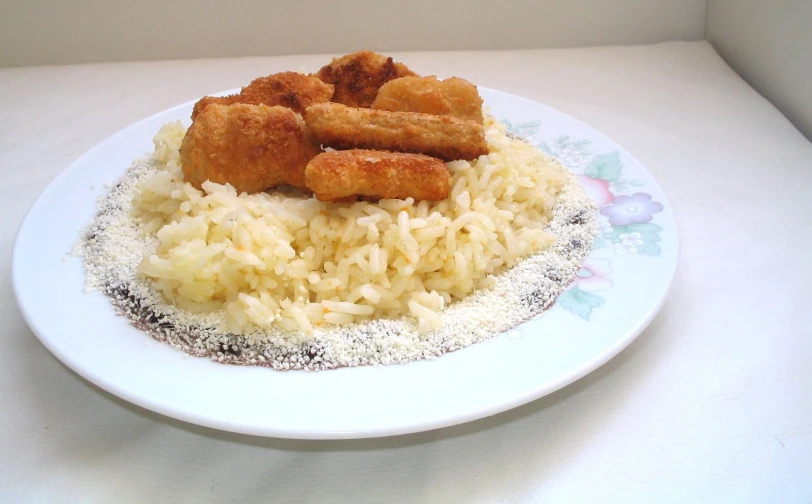 a white plate topped with rice and chicken fingers