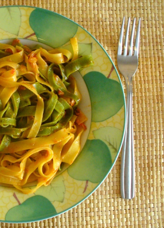 a plate of pasta with green beans and yellow sauce