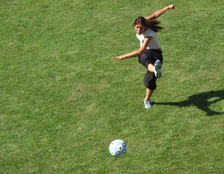 a person kicking a soccer ball around on a field