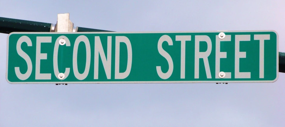 a sign is mounted to the corner of second street