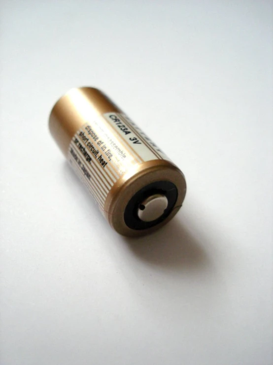 a gold colored batteries are placed on a white surface