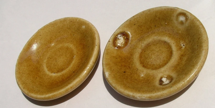 two small circular dishes on a white surface