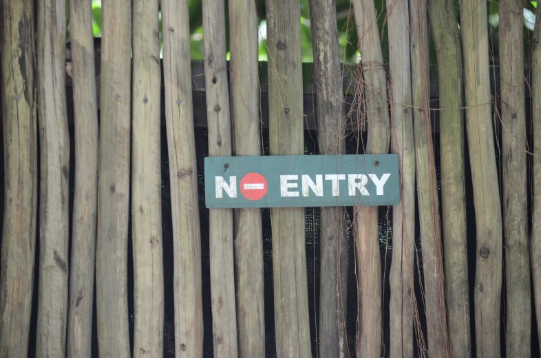 a fence with wooden posts and a sign saying no entry