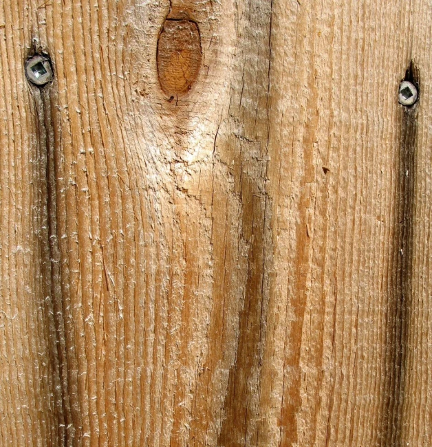 the wooden surface has two holes for nails to attach them