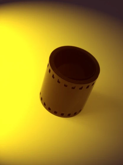 a round paper cup on a yellow surface