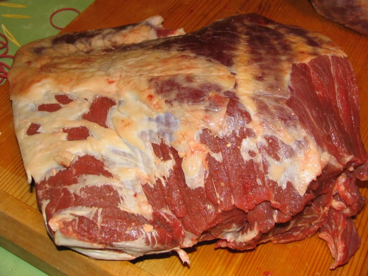 a group of large chunks of meat on a wooden  board