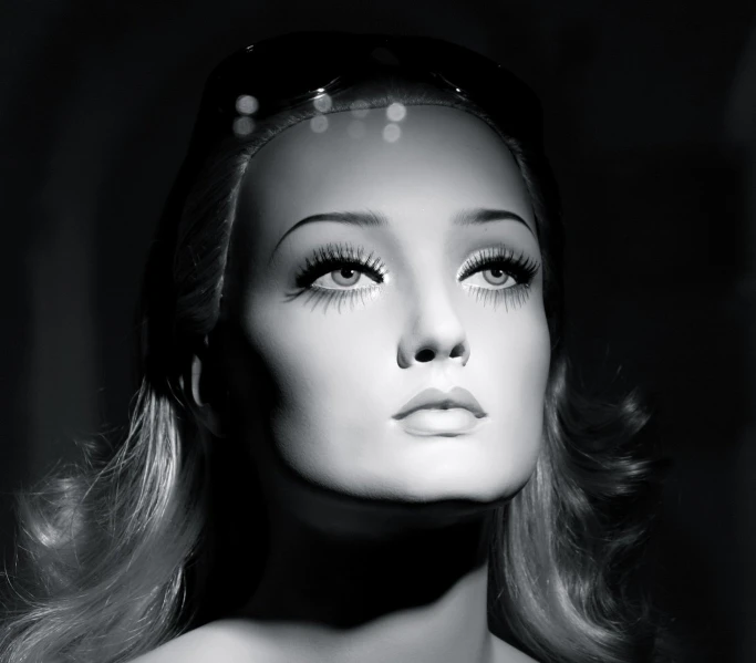 a black and white image of a barbie with hair and makeup