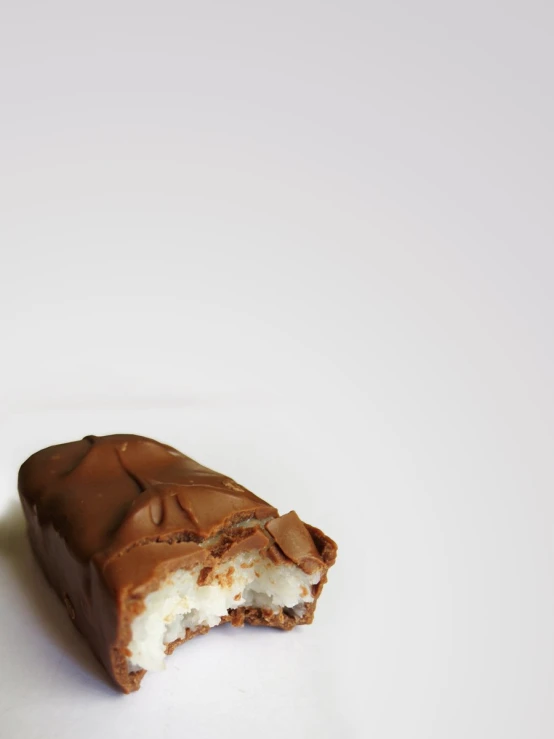 half eaten chocolate covered pastry on white surface