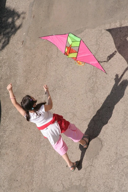 a  standing on top of a street flying a kite