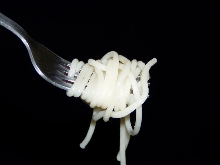 a fork with noodles on it that is partially eaten