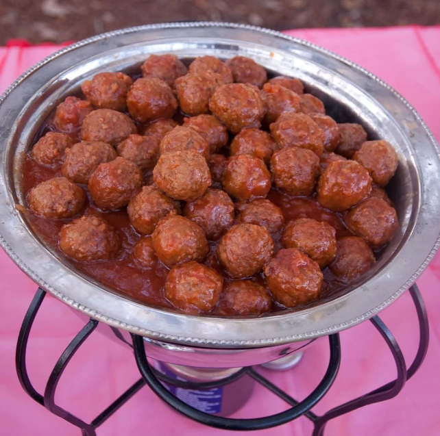 meatballs are in sauce in a stainless pan