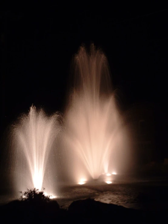 a water fountain shooting out and glowing from below