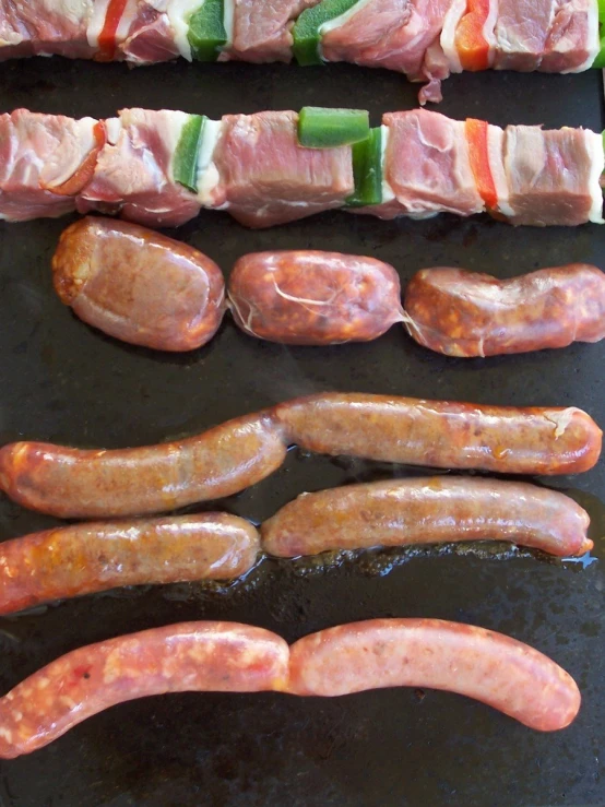 an assortment of meat items including  dogs and other foods