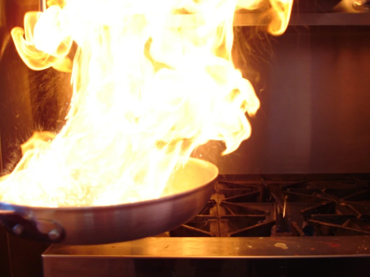 a wok with flames in it on the stove