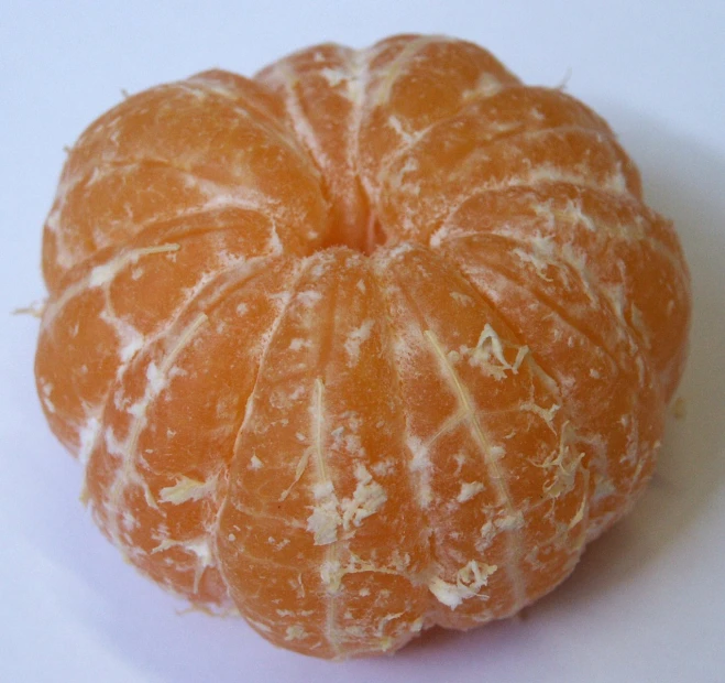 a peeled orange sitting on a white surface