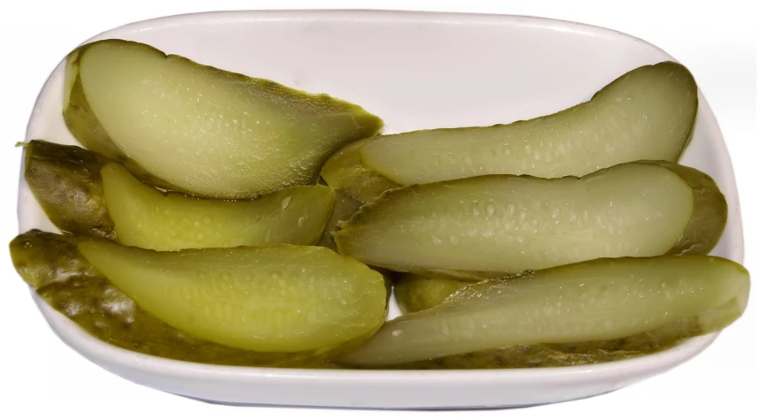 sliced pickles in white bowl with water droplets