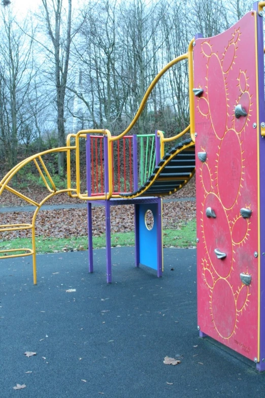 colorful playground equipment in a park next to trees