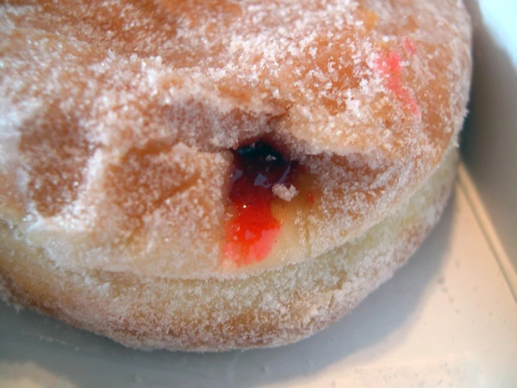 a powdered donut with powdered sugar and jelly on it