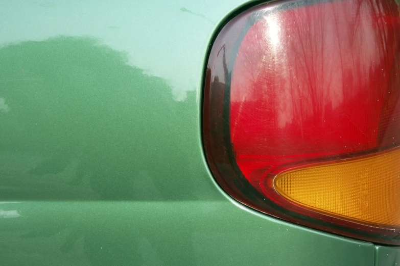 the rear of a green car with red taillights