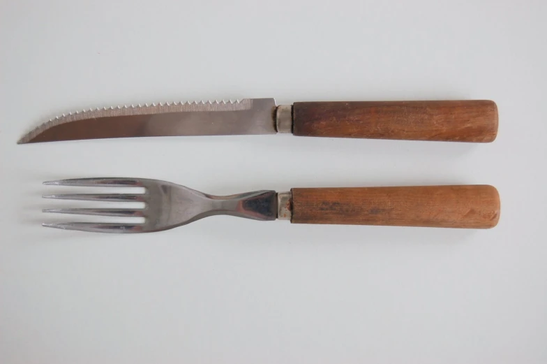 two forks with handle and wooden handles next to each other