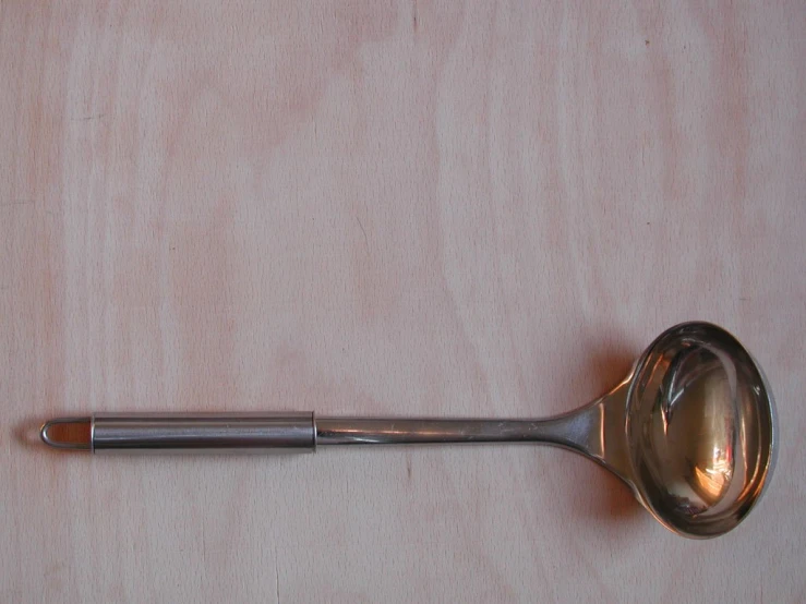 a spoon on top of a table next to a ruler