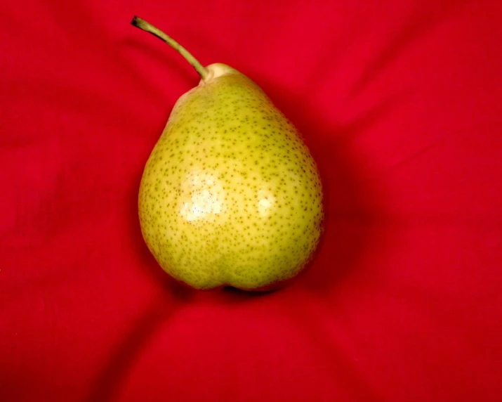 the pear is on the red surface, top view