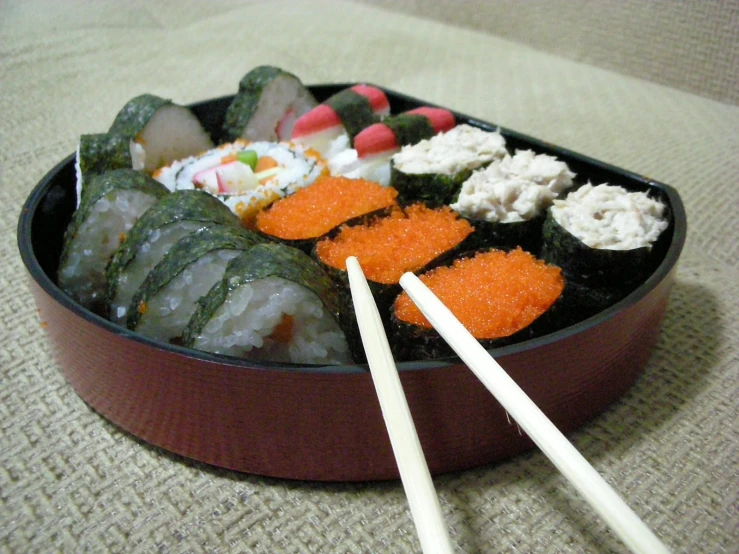 a tray filled with different foods and chopsticks