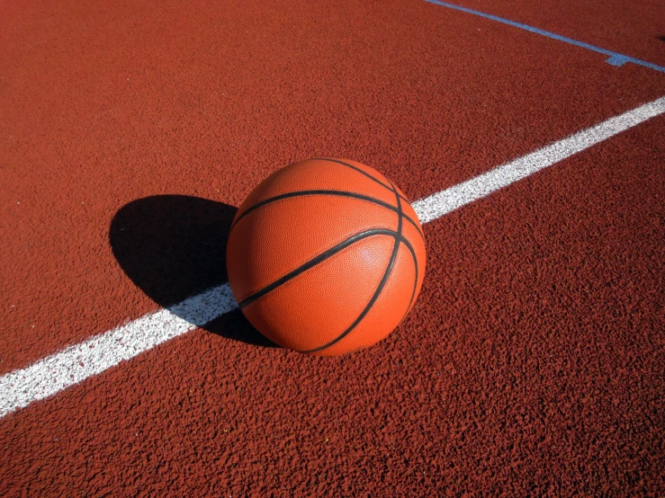 an orange basketball sitting on top of a basketball court