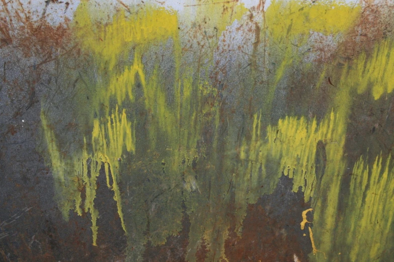 a rusty wall with green and yellow paint
