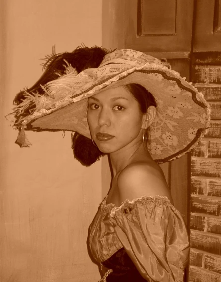 a woman wearing a long, lacy top, and hat