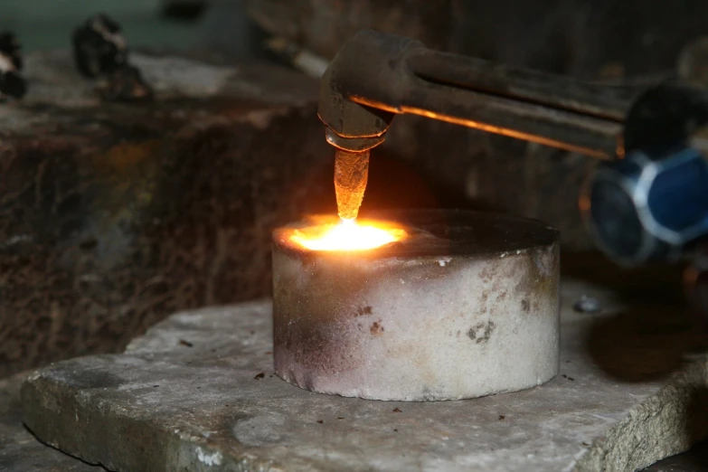 a metal object being cast with a furnace